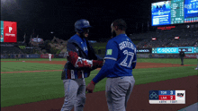 a baseball player with the number 27 on the back of his jersey shakes hands with another player