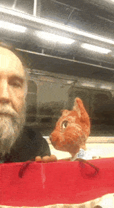 a man with a beard is holding a stuffed cat