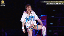 a female wrestler wearing a shirt that says ' marvel ' on it