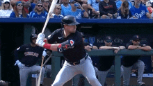 a baseball player in a cleveland uniform is swinging a bat