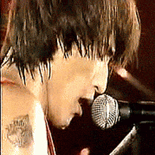 a close up of a person singing into a microphone
