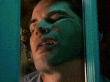 a close up of a man 's face with a green mask on it .