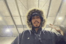 a man wearing a fur hooded jacket with the letter a on the front