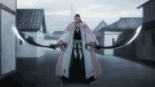 a man in a pink robe is holding two swords in front of buildings