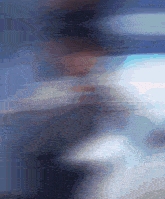 a blurry picture of a person in a dark room with a blue background