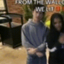 a blurry picture of a man and a woman standing in front of a sign that says from the wall welt