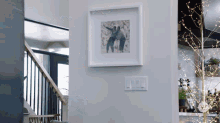 a picture of a man and woman in a frame hangs on a wall