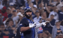 a baseball player wearing a helmet that says detroit stands in front of a crowd