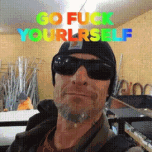 a man wearing sunglasses and a beanie has the words go fuck yourself above his head