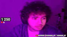 a man with curly hair is wearing headphones and looking at the camera in a purple light .