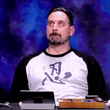 a man with a beard is wearing a shirt with chinese characters on it