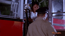 a man in a white shirt is talking to a police officer in a man laksa movie
