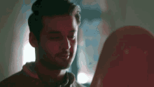 a man with his eyes closed looks at a woman with a hijab on