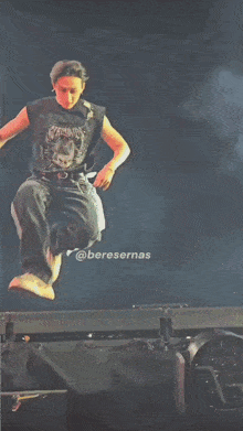 a man is standing on a stage wearing a black tank top with a bunny on it .
