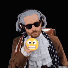 a man wearing a wig and sunglasses holds a smiley face