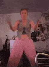 a woman in pink pants and a tan vest is dancing