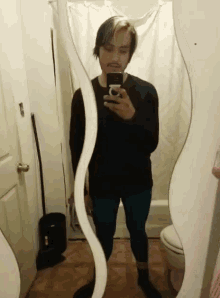 a man taking a selfie in front of a mirror