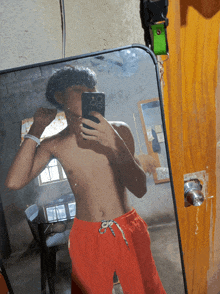 a man taking a picture of himself in a mirror with his phone