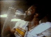 a man is drinking water from a bottle in a dark room .