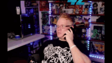 a man wearing glasses is talking on a cell phone while wearing a shirt with the number 20 on it