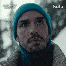 a man wearing a blue beanie and a turtleneck is featured in an ad for nine perfect strangers