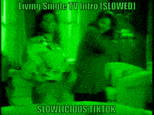 a couple of people standing next to each other in a living room with a green light behind them .