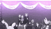 a group of people standing in front of a stage with banners that say peace and world