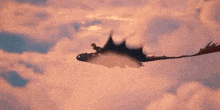 a blurred image of a cloudy sky with a few birds flying through it