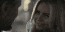 a man and a woman are looking at each other in a dark room