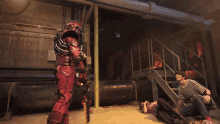 a man in a striped shirt is kneeling down next to a robot