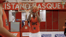 a basketball player with spfc 14 on his jersey throws the ball
