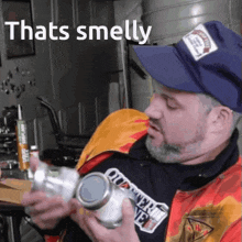 a man wearing a blue hat is holding a jar that says thats smelly on it