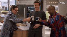 three men are toasting in a kitchen with a hulu logo in the background