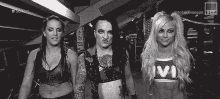three women are standing next to each other and one of them is wearing a shirt with the word vi on it