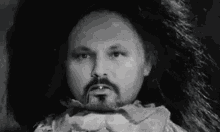 a black and white photo of a man with a beard and a large afro wig .