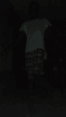 a person wearing a plaid shirt and a white tank top