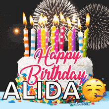 a birthday cake with candles and fireworks in the background for alida .