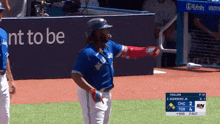 a baseball player in a blue jays uniform stands on a field