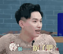 a man is sitting at a table with a microphone in front of him and talking into it .