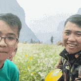two men are posing for a picture in a field of flowers and one of them is wearing a jacket that says the north face