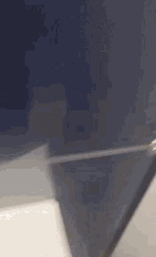 a blurred image of a person holding a knife in a bathroom .