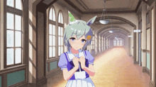a girl in a blue and white dress is standing in a hallway with lots of windows