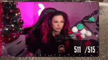 a woman with red hair is sitting in front of a microphone with the number 511 on the bottom