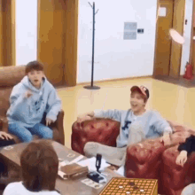 a group of people are sitting in a living room playing a game of chess .