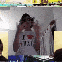 a man wearing a shirt that says i love swag is giving the middle finger