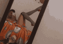 a man taking a picture of himself in a mirror with his legs crossed