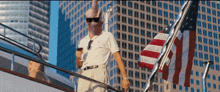 a man standing on a boat with an american flag in the background