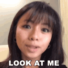 a close up of a woman 's face with the words look at me above her