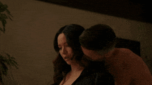a man is kissing a woman on the neck in a dark room