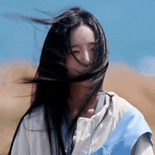 a woman 's hair is blowing in the wind behind her face